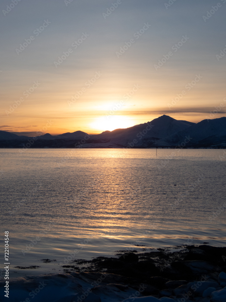Sunset over the sea and mountains on the background at the time when the polar night has just ended. Sunset over the sea and mountains on the background at the time when the polar night has just ended.