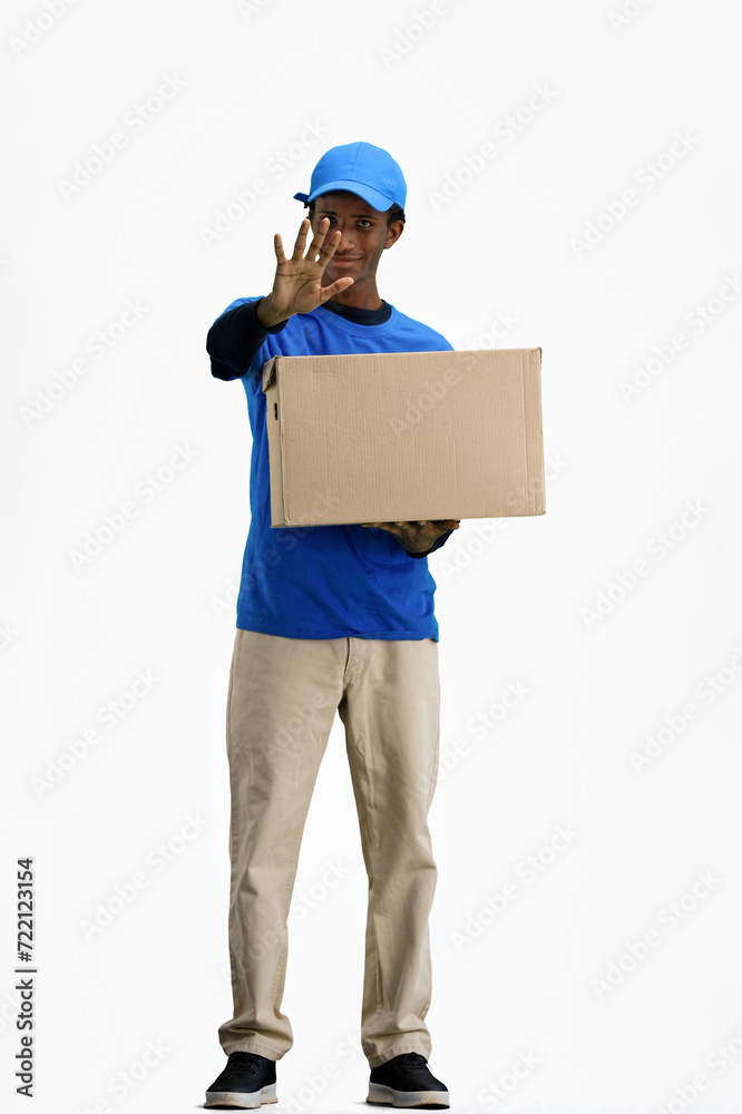 The deliveryman, in full height, on a white background, with a box, shows a stop sign The deliveryman, in full height, on a white background, with a box, shows a stop sign