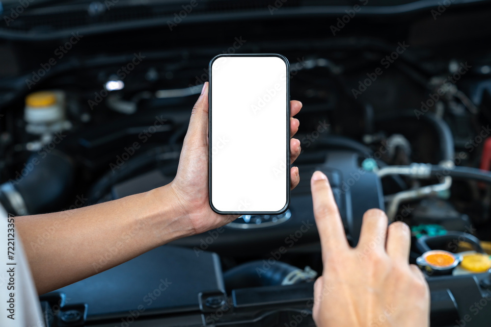 A woman uses a mobile phone to take a picture of the engine