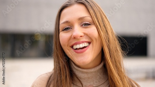 Young female student smiling at camera outdoors