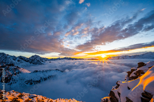Mount Siguniang, Four Girls Mountain the Sacred Mountain in the East, National Geo-park of China, Sunset over a sea of clouds in the mountains with golden light touching snowy peaks