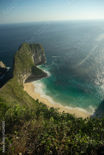 A breathtaking view of a secluded beach cove surrounded by steep cliffs and lush greenery