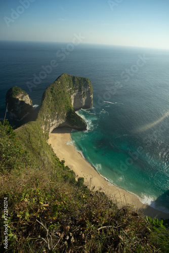 A breathtaking view of a secluded beach with towering cliffs and turquoise waters