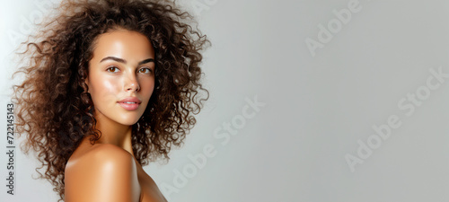 Model girl with shiny smooth healthy hair with curly hair and glowing, tan skin natural beauty smooth skin for Care, and hair and skin care products
