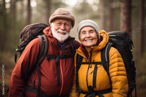 Senior couple hiking in the forest. They are looking at camera and smiling
