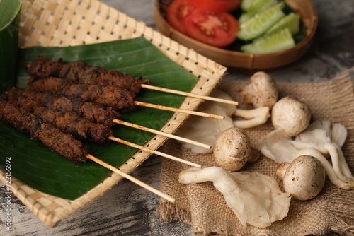 Sate Jamur, is a satay made from oyster mushrooms and edible mushrooms grilled with peanut sauce. This food is suitable for dieters and vegetarians or vegans. Indonesian food. Jamur merang tiram.  photo