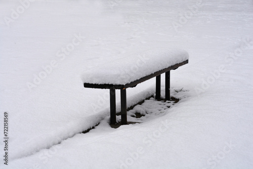 Bench covered in snow in winter
