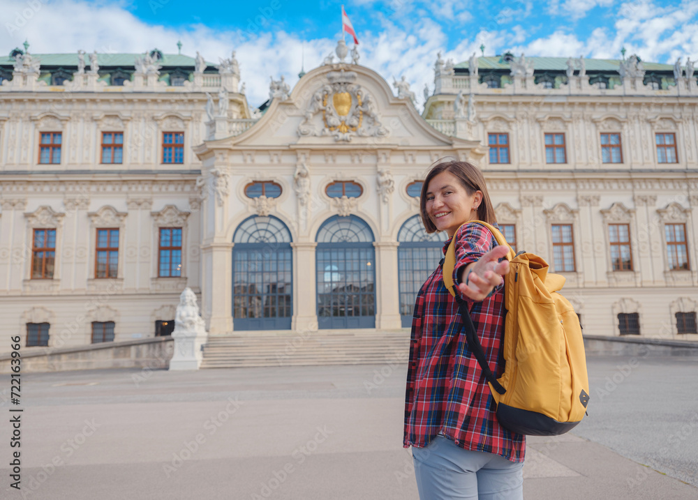 Female tourist traveling in Austria, capital city Vienna. summer female solo trip to Europe, happy young woman walking in park near Belvedere palace complex in Baroque style.