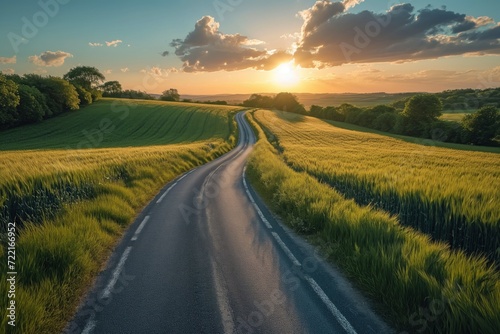 A road in the middle of a green landscape at sunset. Une route au milieu d'un paysage de verdure au coucher de soleil. photo