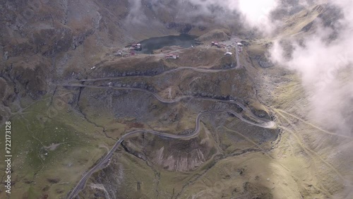 Curvy mountain road with lake and cabin at top