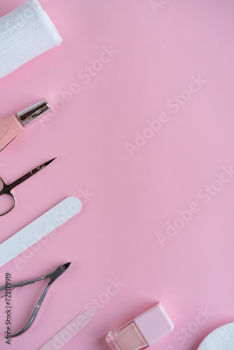 Salon manicure concept photo. Manicure equipment with nail polish and rose petals pink background top view space for text