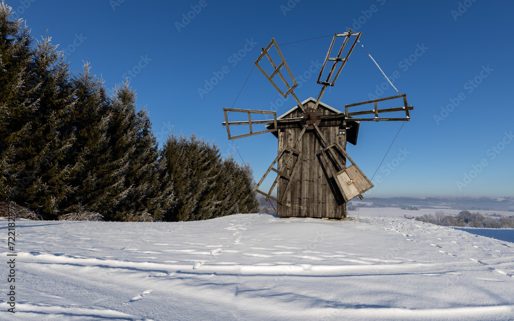 Old mill in winter among hills and forests