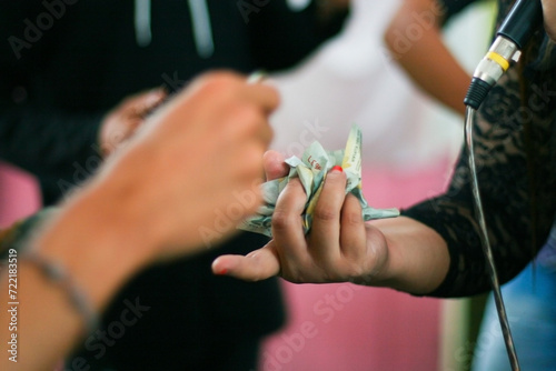 Canvastavla A wedding singer receives saweran money as a gift given by guests who dance wi