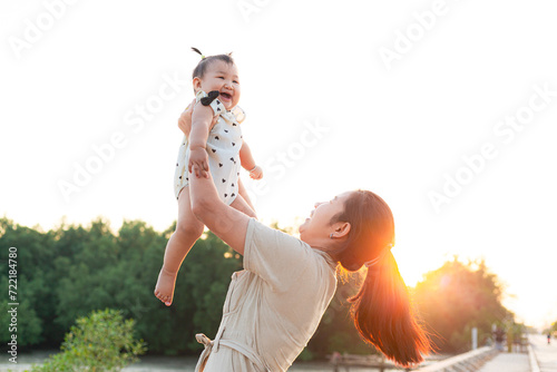 Mother and child playing in the park,Beautiful Asian mother and child play happily in outdoor amusement park, Mother's Day concept.