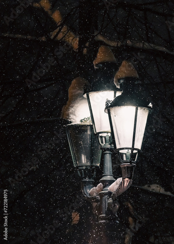 Obraz na płótnie Falling snow against the background of a street lamp w salonie