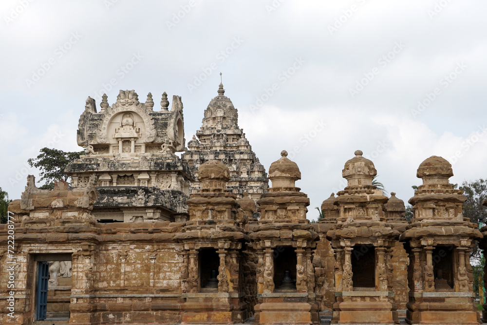 Facade of ancient Kailasanathar temple. Historic Hindu Temple tower with sandstone carvings against cloudy background.