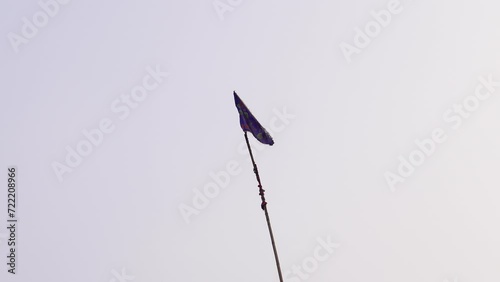A Giant Wooden stick Waves a Flag in the Wind beneath the Delhi Sky. photo