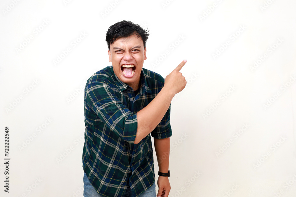 Young asian man laughing while pointing sideways, Isolated on white Young asian man laughing while pointing sideways, Isolated on white