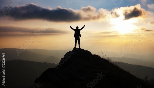 silhouette of a man on top who has reached the top of the mountain 