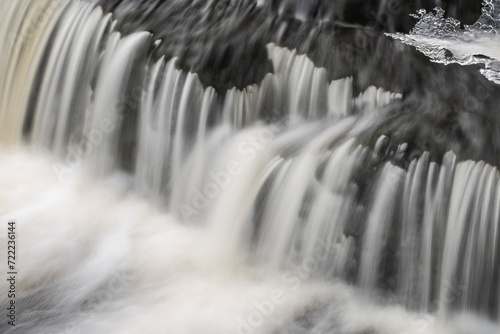 Winter  Bond Falls cascade captured with motion blur and framed by ice  Michigan s Upper Peninsula  USA