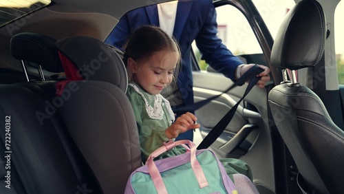 child seat car. father man puts girl daughter child seat car. happy family. schoolboy child seat. happy child car seat. childhood trip with dad. road traffic. road safety rules. girl with school