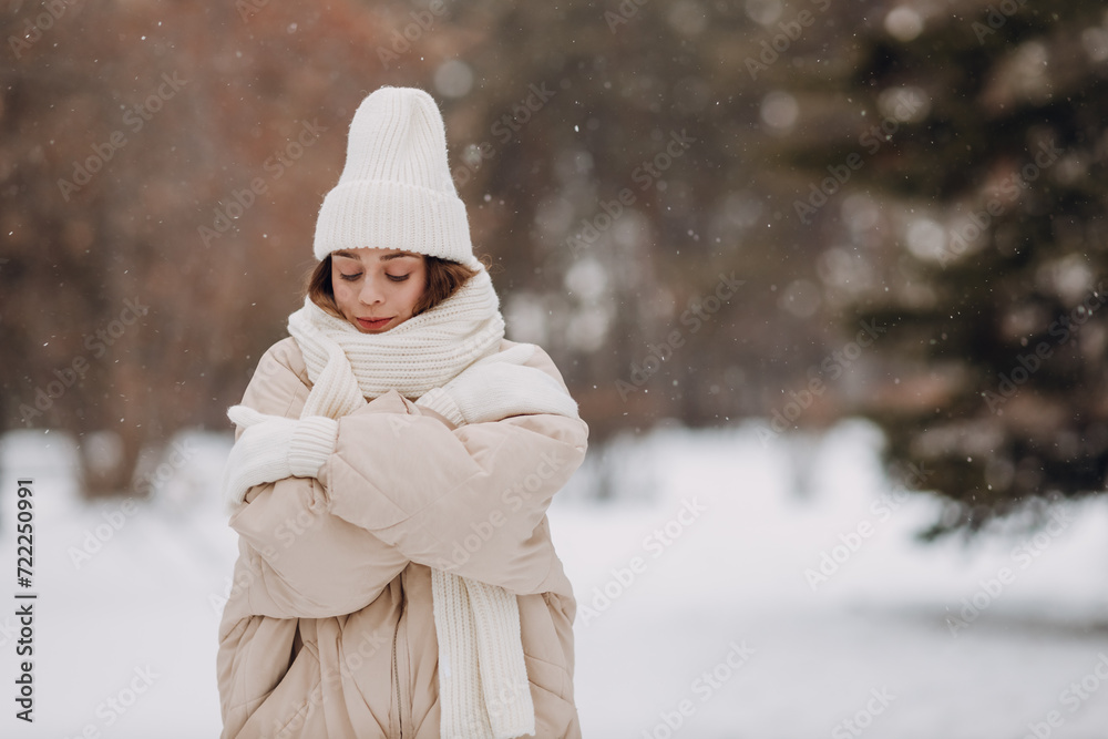 Obraz premium Young woman dressed coat scarf hat and mittens and winter weather at snowy winter park