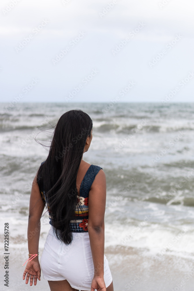 Latin Woman Contemplating Ocean Waves
