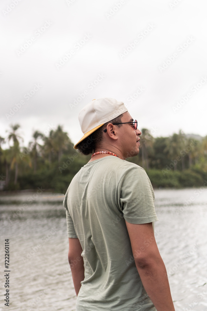 Latin man in reflective moment overlooking calm tropical lake. Latin man in reflective moment overlooking calm tropical lake.