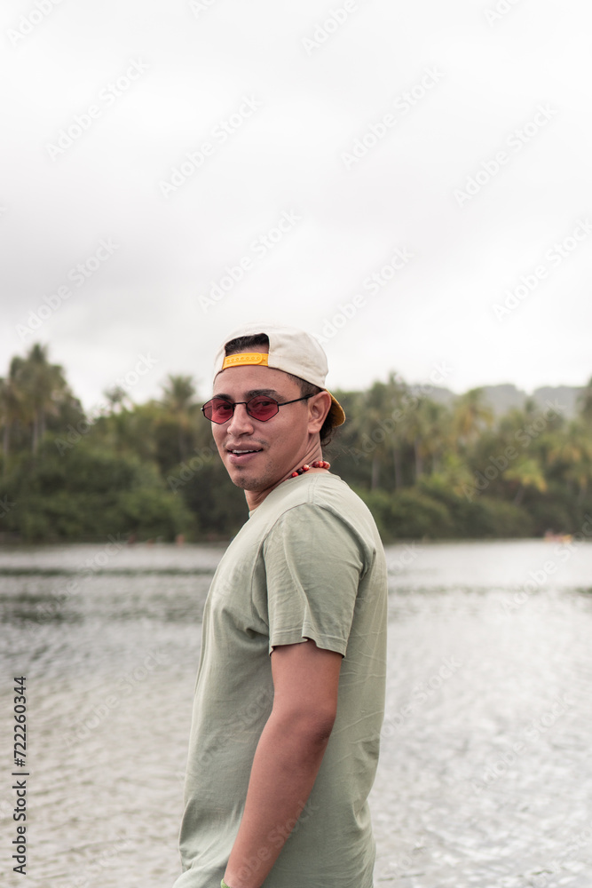 Latin man enjoying tropical lakeside view.