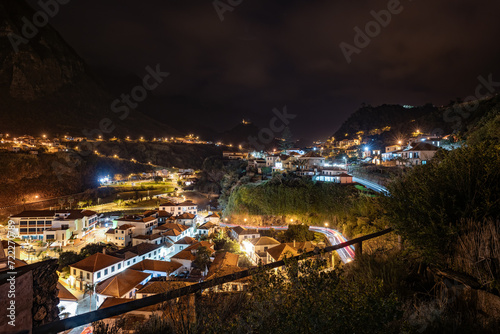 Late night-time atmosphere, street lighting and car light trails of the scenic village on the north coast in a green, overgrown valley. Sao Vincente, Madeira Island, Portugal, Europe.