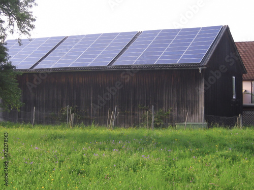 Solar panels are installed on the roof of a private barn to collect solar energy. Renewable green energy and nature conservation