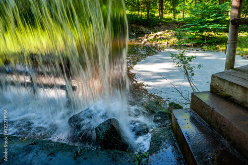 Passage under an artificial waterfall. Wall of water, falling cascade. Vecais parks, Smiltene, Latvia. photo