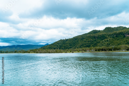 The downstream part of the river empties into the coast of Pacitan, Indonesia. The river downstream is wide and the water flow is calm and quite deep with a beautiful green hilly background