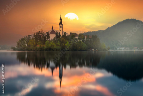 Famous alpine Bled lake (Blejsko jezero) in Slovenia, amazing autumn landscape. Scenic view of the lake, island with church, Bled castle, mountains and blue sky with clouds, outdoor travel background photo