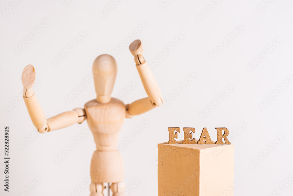 The word fear and a wooden man throwing up his hands in horror The word fear and a wooden man throwing up his hands in horror