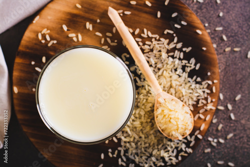 Close up of lactose-free rice milk in a glass and rice cereal on the table top view photo