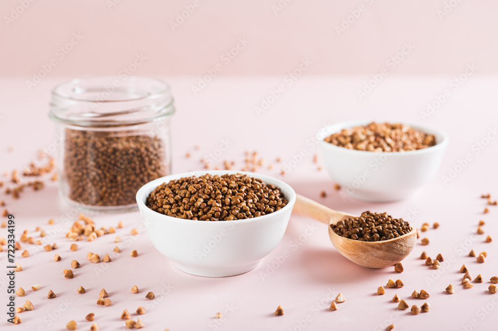 Dry buckwheat tea granules in a bowl, spoon and jar on the table Dry buckwheat tea granules in a bowl, spoon and jar on the table