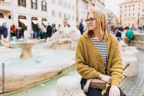 Happy Woman in glasses walking in the old town. Fontana della Barcaccia, little boat, Piazza di Spagna at Rome. Concept of happy vacations, traveling famous italian landmarks photo