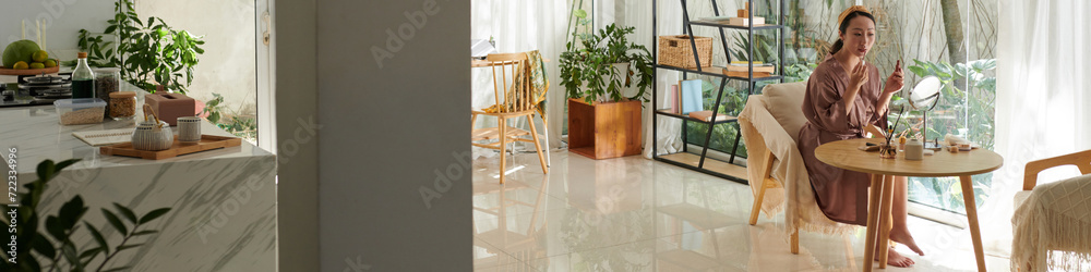 Header with woman getting ready at home, applying makeup Header with woman getting ready at home, applying makeup