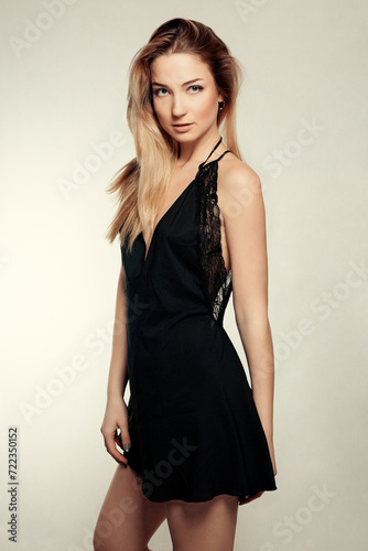 Portrait of beautiful blonde woman in black dress. Fashion photo