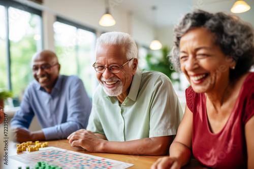 Multiracial seniors having fun during board game in geriatric clinic or nursing home photo