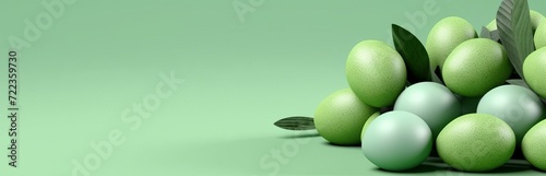 A group of green Easter eggs with leaves on a plain light green background. Calm and spring design. Concept: holiday themes, spring events and advertising of seasonal products 