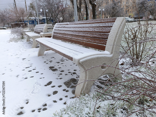 A snow-covered bench in the city park