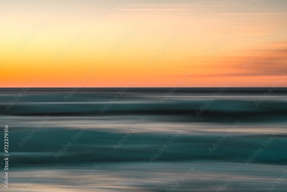 Fototapeta premium Creative abstract background. Sea and sky at sunset, motion blur