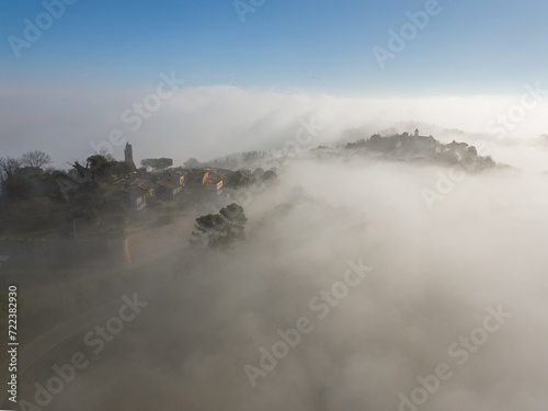 Italy, January 28, 2024: aerial view of the medieval village of Fiorenzuola di Focara immersed in fog. We are in the San Bartolo park near Pesaro in the Marche region
