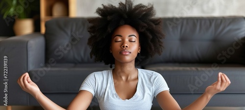 Serene young woman meditating at home, promoting mental health and relaxation for stress relief.