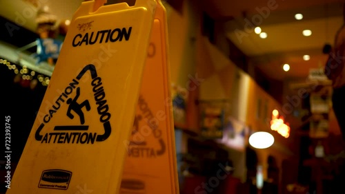 Woman almost slips on wet floor - wet floor sign in foreground photo