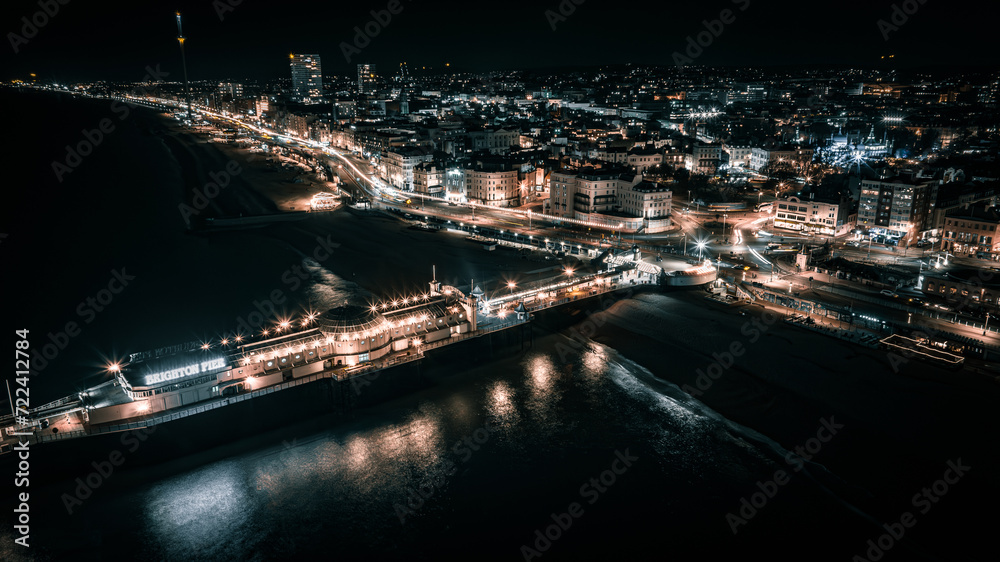 Aerial view of a seaside, Brighton Pier and beach in night lights, Brighton, East Sussex, UK