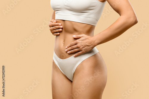 Young Female In White Underwear Touching Belly With Two Hands