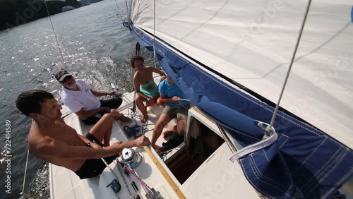 Woman, man, boy and bearded man on yacht with white sail  photo